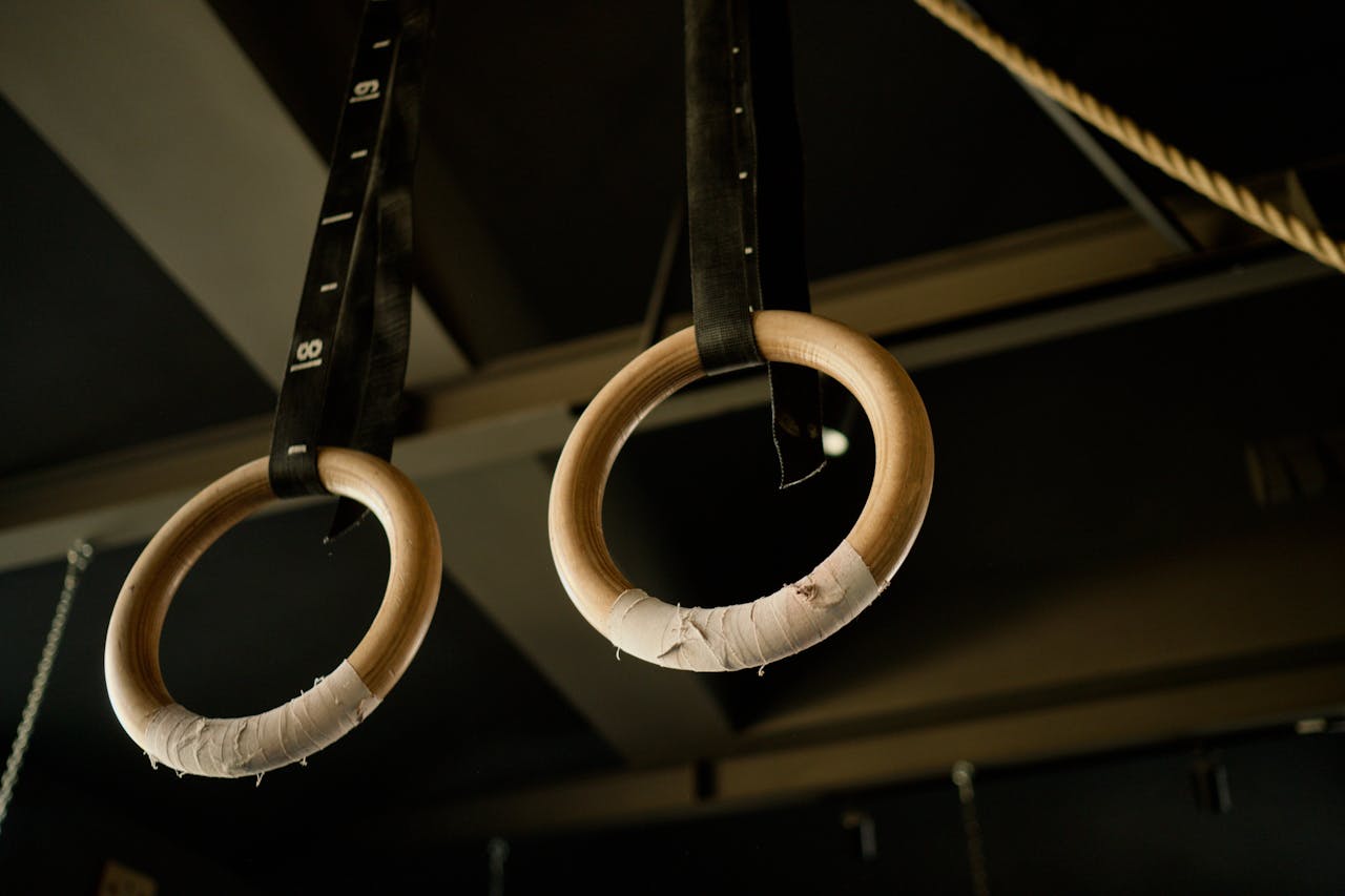 Close-up of wooden gymnastic rings hanging in a fitness gym.